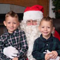 Two little boys sitting on Santa's lap.
